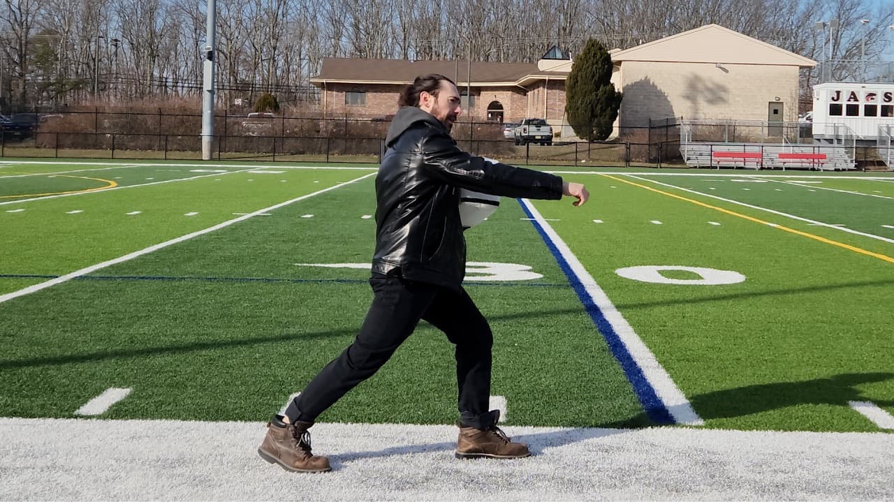 Dr. J. L. Natale demonstrating a weight-transfer stance on a field.